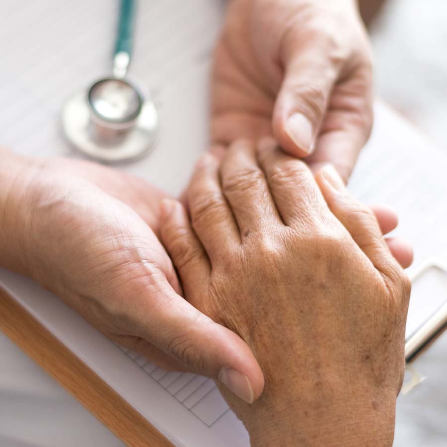 doctor holding elderly hand